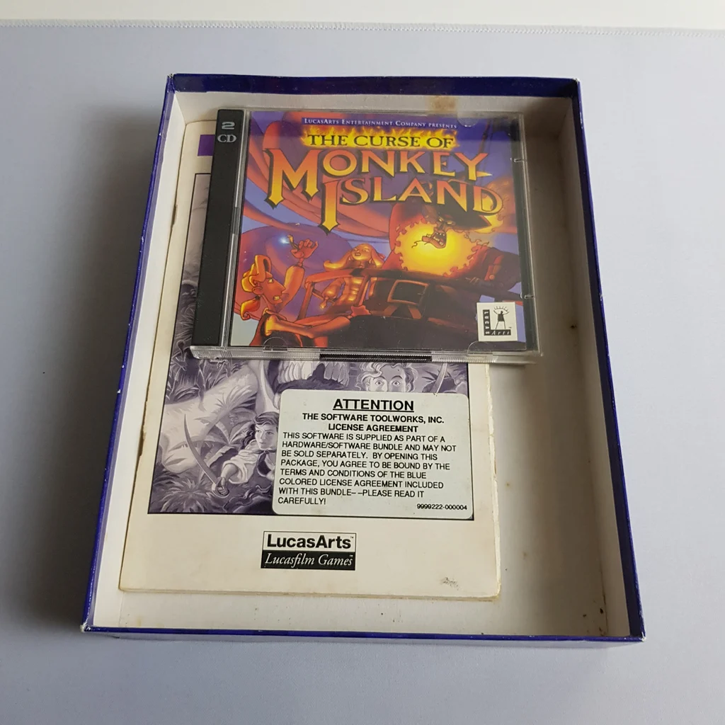 A The Curse of Monkey Island játék dobozának belseje, benne CD tok és dokumentáció.