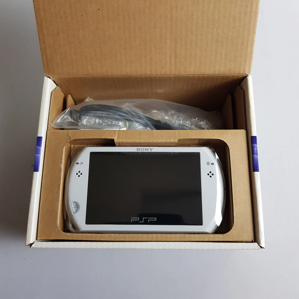 A Sony PSP Go kézikonzol a dobozban, kiegészítő kábelekkel.