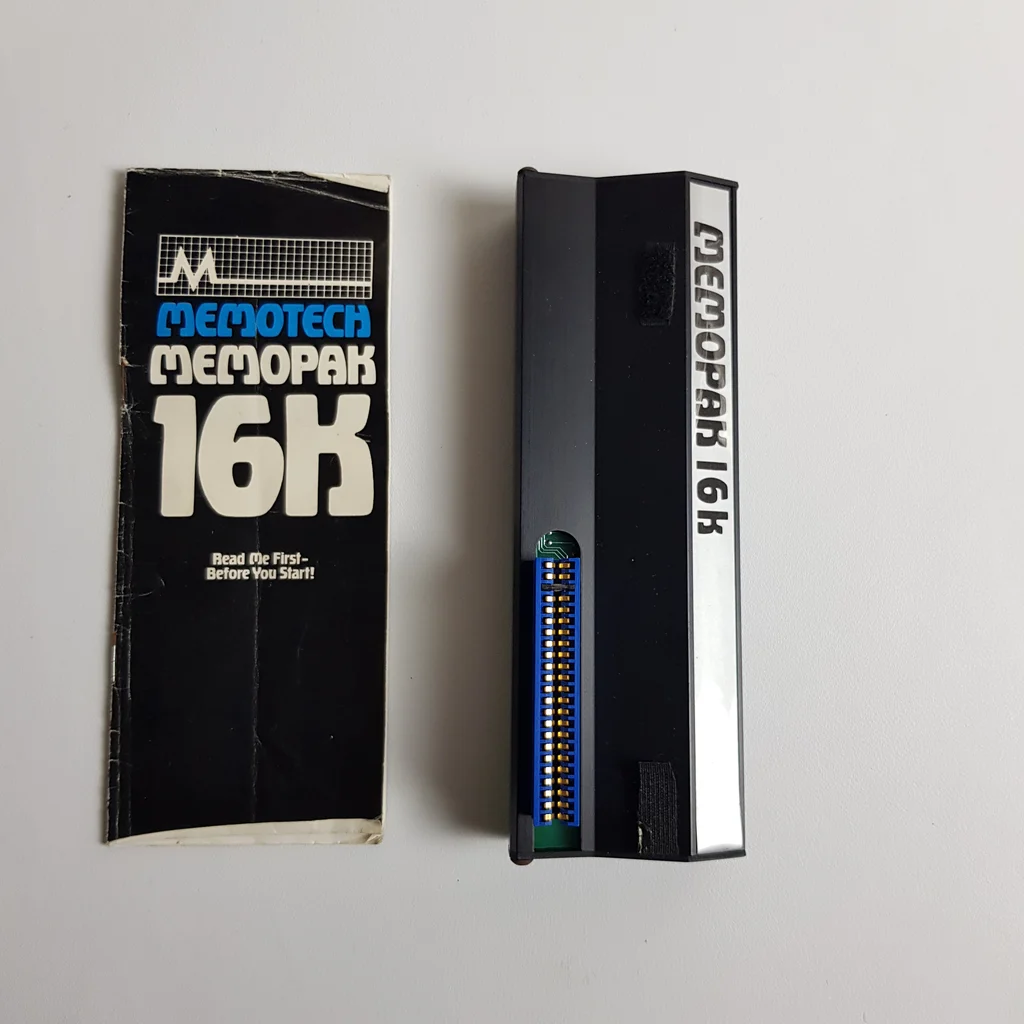 Memotech Memopak 16K memóriabővítő és használati útmutató elölről fotózva fehér háttéren.