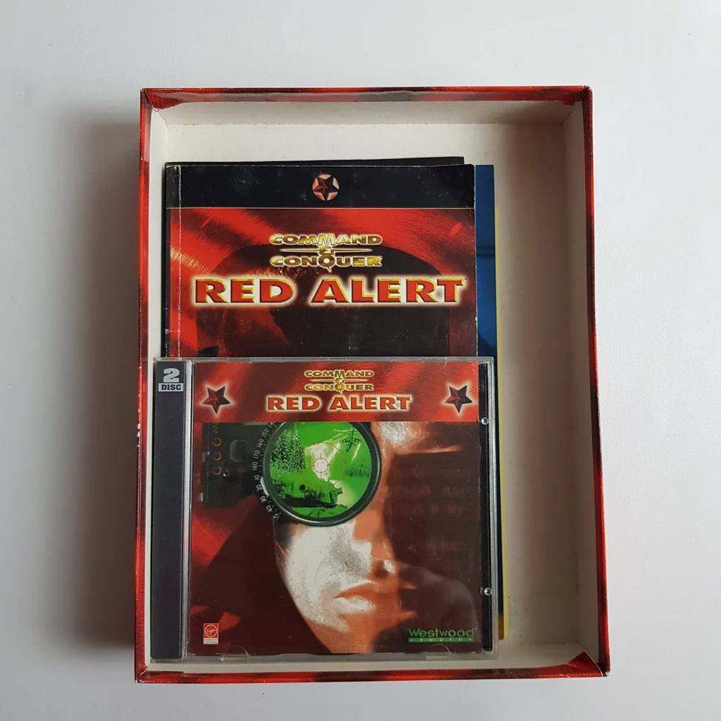 Command & Conquer: Red Alert PC játék doboz tartalma, kézikönyv és CD tok látható a dobozban.