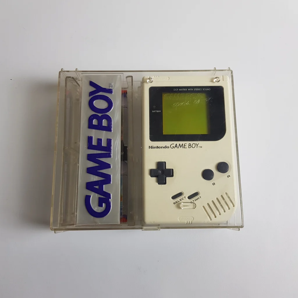 Eredeti Nintendo Game Boy kézi konzol átlátszó műanyag tokban, bal oldalon Game Boy felirattal.