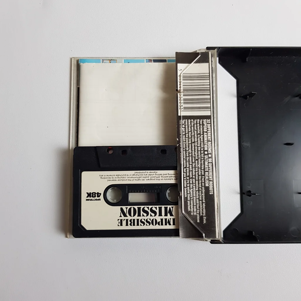 Impossible Mission Spectrum 48K kazetta és borító Impossible Mission Spectrum 48K játékkazetta félig kihúzva a dobozból, fehér háttéren.